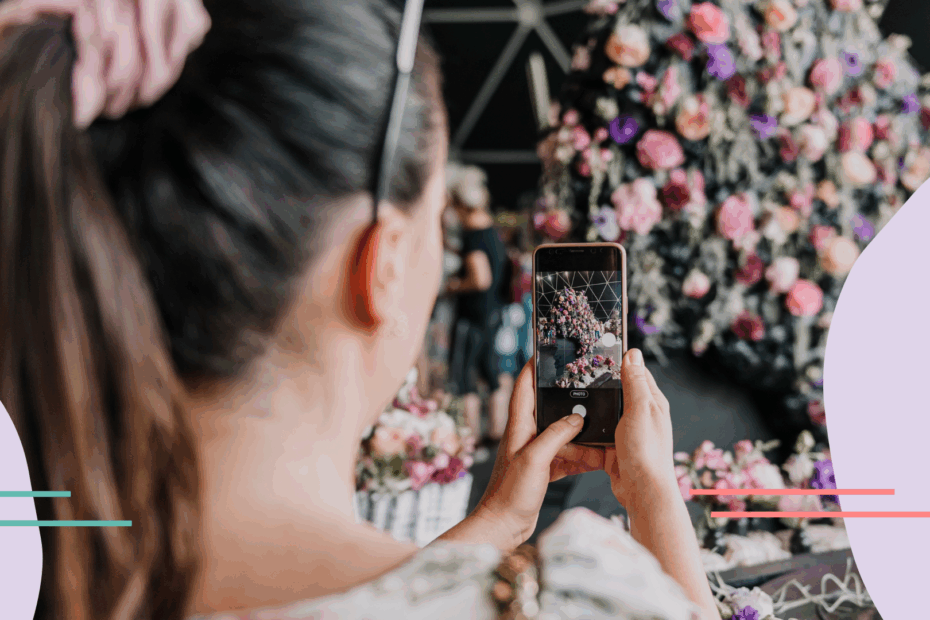 woman taking pictures of floral display